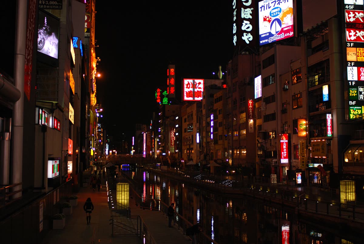 Dotonbori canal at night, illuminated signage reflecting on the water